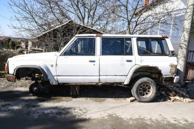 Tekerleksiz eski paslı araba. 