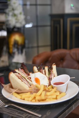 Lezzetli sandviç ve beyaz tabakta kızarmış yumurta..