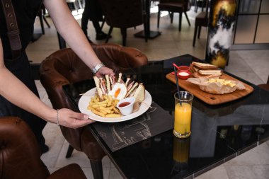 Lezzetli sandviç ve beyaz tabakta kızarmış yumurta..