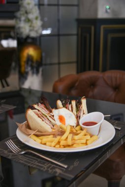 Lezzetli sandviç ve beyaz tabakta kızarmış yumurta..