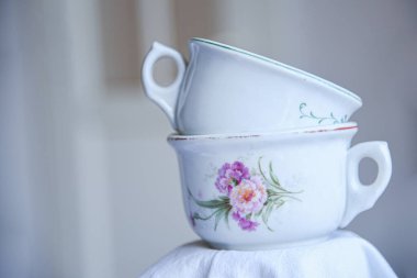 Birbiri ardına çiçek desenli çay fincanları. Tarafsız arka planda eski moda porselen bardaklar. Boş kopyalama alanı, metin için boşluk