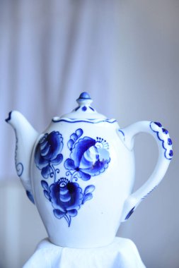 Retro porselen çaydanlık. Mavi çiçekli parlak beyaz bir porselen. Boş kopya alanı olan tarafsız bulanık arkaplan çaydanlığı