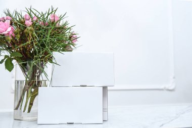 Boş şablon beyaz karton kutu paketleri ve çiçekli vazo. Boş kopyalama alanı
