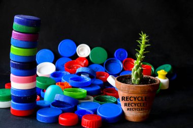 Siyah arka planda boş kopya alanı olan şişe kapakları. Geri Dönüşüm 