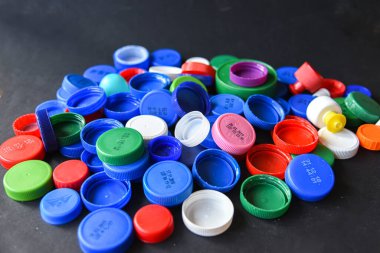 Siyah arka planda boş kopya alanı olan şişe kapakları. Geri Dönüşüm 