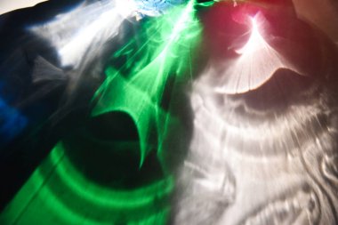 Camın içinden ışık geçiyor. Beyaz arkaplanda soyut renkli gölgeler. 