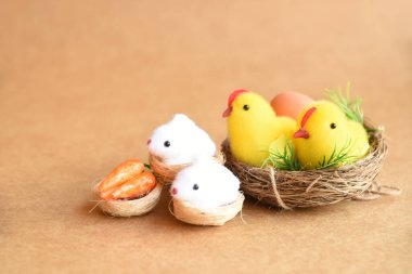 Yuvada yeni doğmuş tavukların neşeli Paskalya sahnesi, tavşanlar, havuçlar, yumurtalar ve doğal doğal arkaplanda dekorasyon. boş kopyalama alanı Mutlu Paskalyalar