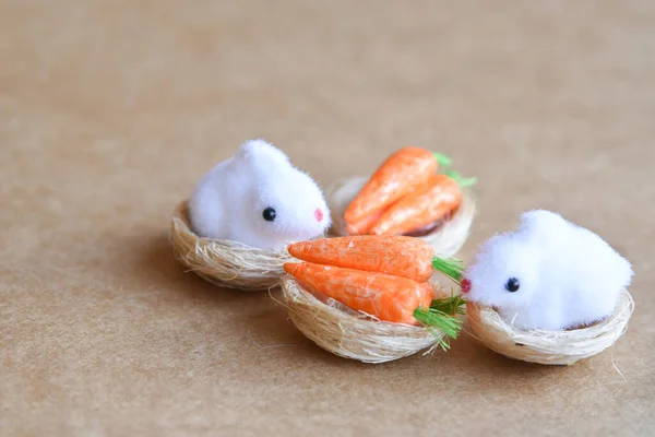 Joyful Easter scene of new born chickens in nest, bunnies, carrots, eggs and decoration on natural neutral background.  Empty copy space.Happy Easter