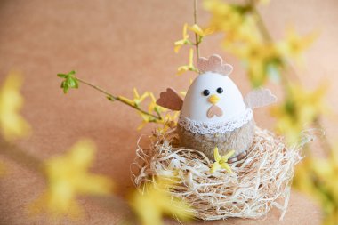 Güzel bir Paskalya süsü. Tavşanlar, tavuklar, yumurtalar, yuvalar, havuçlar, çiçekler ve ruh. Çiçekli salıncakta tavşan, anne tavuk ve yumurta. 