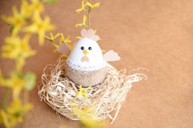 Güzel bir Paskalya süsü. Tavşanlar, tavuklar, yumurtalar, yuvalar, havuçlar, çiçekler ve ruh. Çiçekli salıncakta tavşan, anne tavuk ve yumurta. 