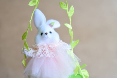 Güzel bir Paskalya süsü. Tavşanlar, tavuklar, yumurtalar, yuvalar, havuçlar, çiçekler ve ruh. Çiçekli salıncakta tavşan, anne tavuk ve yumurta. 