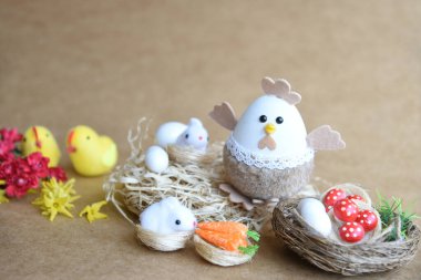 Güzel bir Paskalya süsü. Tavşanlar, tavuklar, yumurtalar, yuvalar, havuçlar, çiçekler ve ruh. Çiçekli salıncakta tavşan, anne tavuk ve yumurta. 