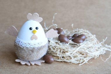 Yuvadaki Paskalya yumurtaları. Çikolata yumurtaları, tavşanlar, çiçekler ve doğal arka plan süslemeleri. Boş kopya alanı olan Paskalya arkaplanı