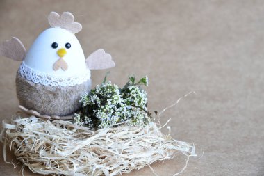 Yuvadaki Paskalya yumurtaları. Çikolata yumurtaları, tavşanlar, çiçekler ve doğal arka plan süslemeleri. Boş kopya alanı olan Paskalya arkaplanı