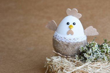 Yuvadaki Paskalya yumurtaları. Çikolata yumurtaları, tavşanlar, çiçekler ve doğal arka plan süslemeleri. Boş kopya alanı olan Paskalya arkaplanı