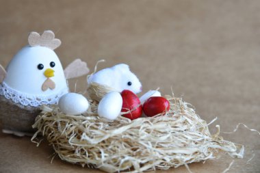 Yuvadaki Paskalya yumurtaları. Çikolata yumurtaları, tavşanlar, çiçekler ve doğal arka plan süslemeleri. Boş kopya alanı olan Paskalya arkaplanı