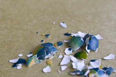 Tarafsız kahverengi ve beyaz arka planda ezilmiş Paskalya yumurtası parçaları. Kırık yumurta kabuğunu kapat. Mutlu Paskalyalar. Boş kopyalama alanı