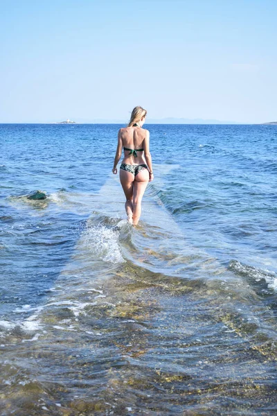 Blond Przystojny Dziewczyna Apartamencie Pływackim Stojąc Skalistym Brzegu Patrząc Morze — Zdjęcie stockowe