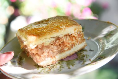 Kadın eli porselen tabakta elmalı turta tutuyor.