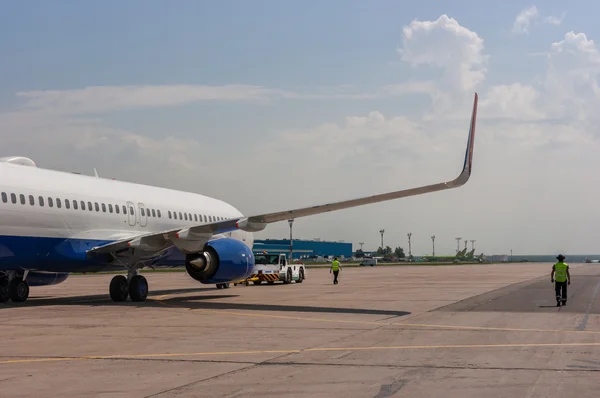 Avión de pasajeros siendo empujado hacia atrás en la pista en el aeropuerto — Foto de Stock