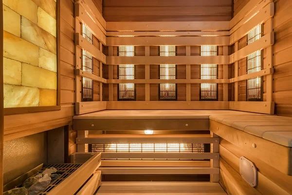 Interior of small wooden finnish sauna with electric heater and infrared panels