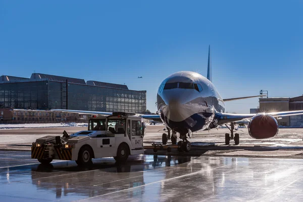 Jet aircraft being pushed back from a hangar on the runway in airport — Stock Photo, Image