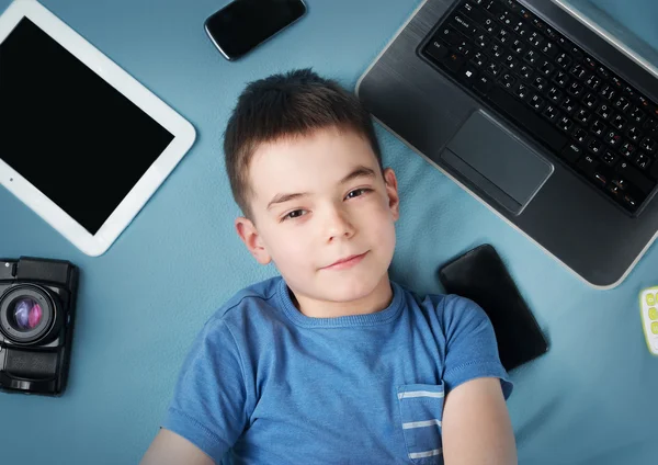 Хлопчик на синьому ковдрі з ноутбуком — стокове фото