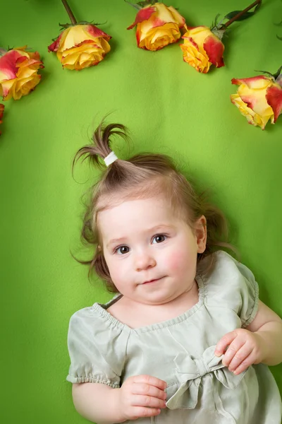 黄色のバラと緑の毛布に横たわってかわいい女の子 — ストック写真