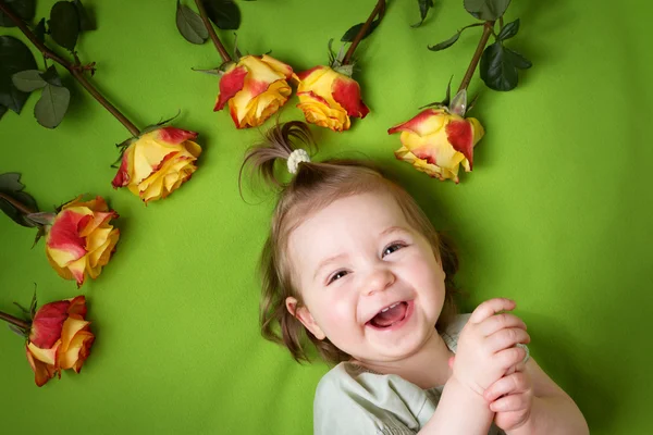 Elég kicsi lány feküdt zöld takaró sárga rózsák — Stock Fotó