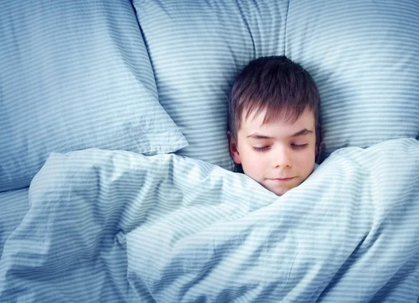 Zeven jaar oude kind in het bed — Stockfoto