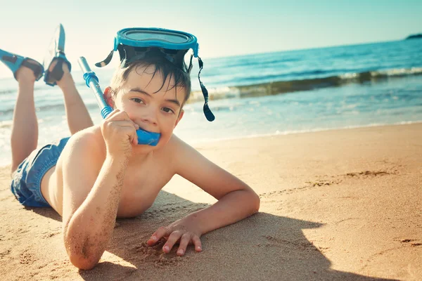 Dítě ležící na pláži s plaveckou maskou — Stock fotografie