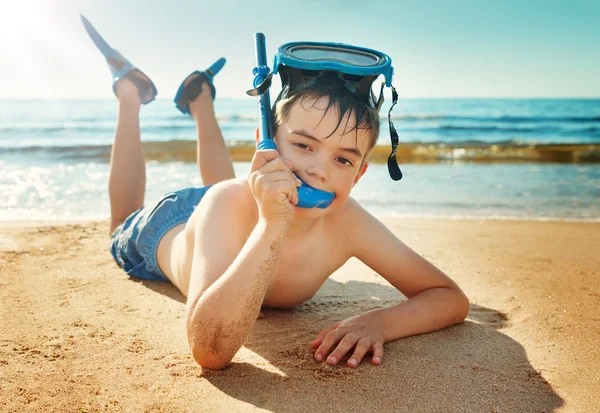 Kind liggend op het strand met zwemmasker — Stockfoto