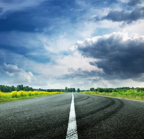 Vista estrada no dia ensolarado de verão com nuvens dramáticas — Fotografia de Stock