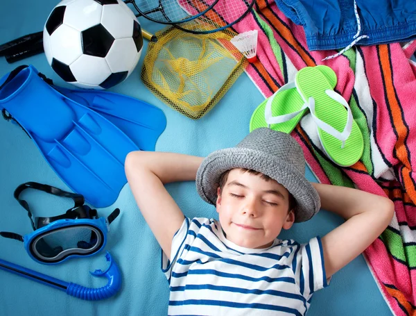 Niño en sombrero de paja con toalla y juguetes —  Fotos de Stock