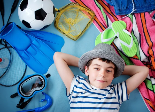 Хлопчик у солом'яній шапці з рушником та іграшками — стокове фото
