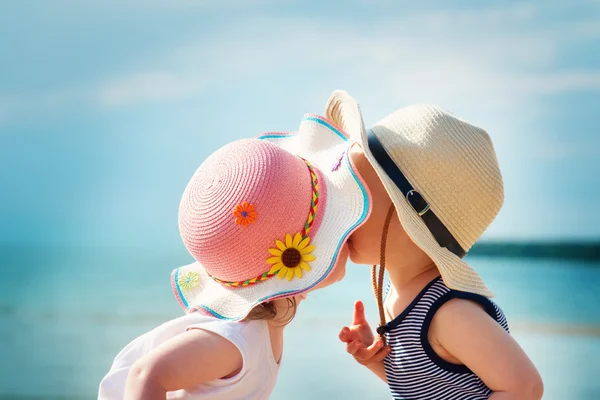 Babymeisje en babyboy zoenen op het strand — Stockfoto