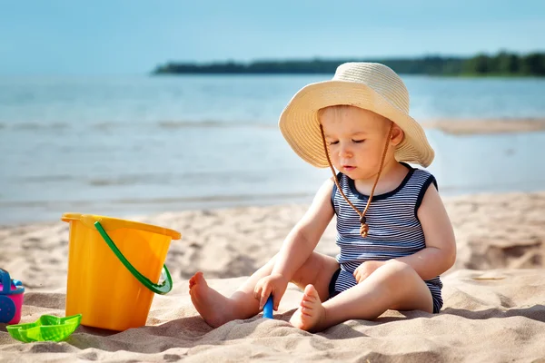 Pojke sitter på stranden i sommardag — Stockfoto