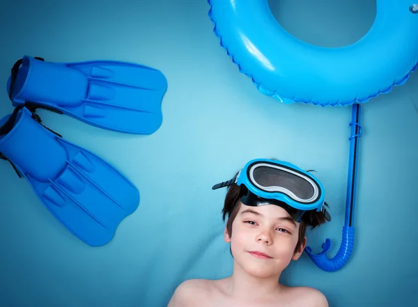 Дитина лежить на синій ковдрі з маскою для плавання — стокове фото