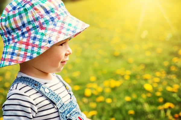 Liten pojke i hatt står på fältet — Stockfoto
