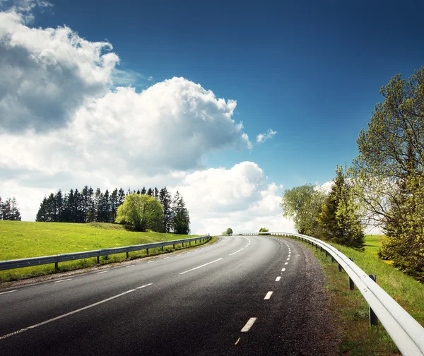 Coche en el camino de asfalto en hermoso día de primavera — Foto de Stock