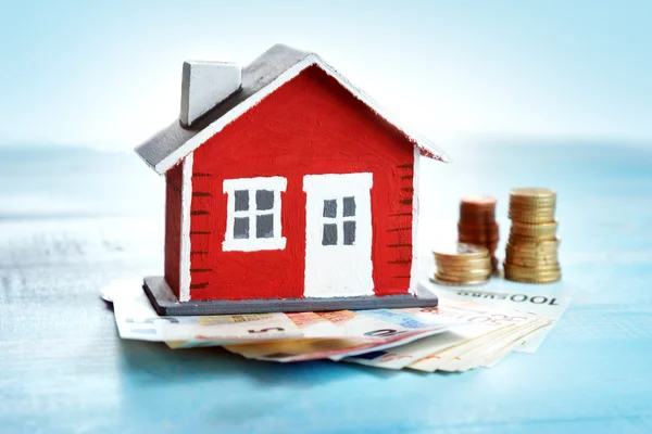 Casa rossa su sfondo di legno con banconote — Foto Stock