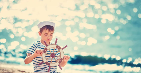 Jongen spelen op het strand met stuurwiel — Stockfoto