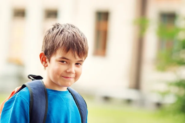 Chlapec s batoh infront z budovy školy — Stock fotografie