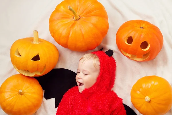 Bambino in costume da diavolo con zucche — Foto Stock