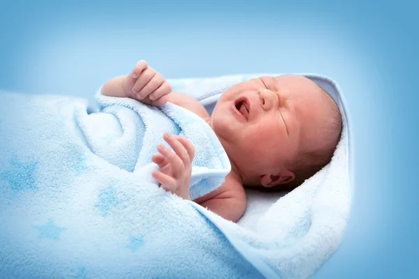Bebé llorón de una semana en manta sobre fondo blanco — Foto de Stock