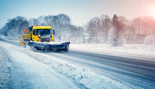 Camión de quitanieves despejando camino nevado después de tormenta de nieve. —  Fotos de Stock