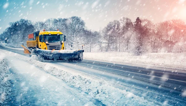 Snow plow truck cleaning snowy road in snowstorm — Stock Photo, Image