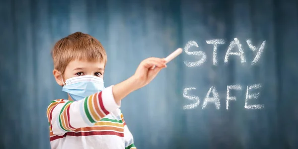 Niño en la máscara de protección de la cara médica en interiores sobre fondo azul. — Foto de Stock