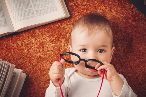 Bebé de un año con gafas y libros —  Fotos de Stock