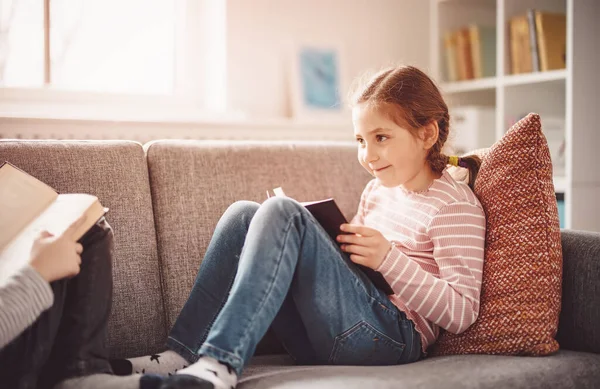 Jolie fille se reposer sur le canapé confortable avec un livre intéressant — Photo